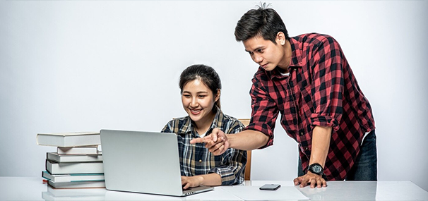 Students discussing plans with study abroad agencies in Kerala while researching on a laptop